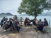 Des gens sont assis sur des bancs au bord du lac.