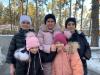 Une mère et ses quatre enfants visitent un parc en tenue d'hiver.
