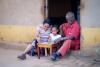 Une famille est assise autour d'une petite table et lit