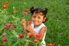 Un enfant cueille des fleurs en souriant.
