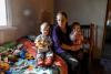 Une mère est assise sur un lit avec deux enfants.