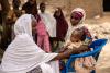 Une femme place un enfant sur une chaise